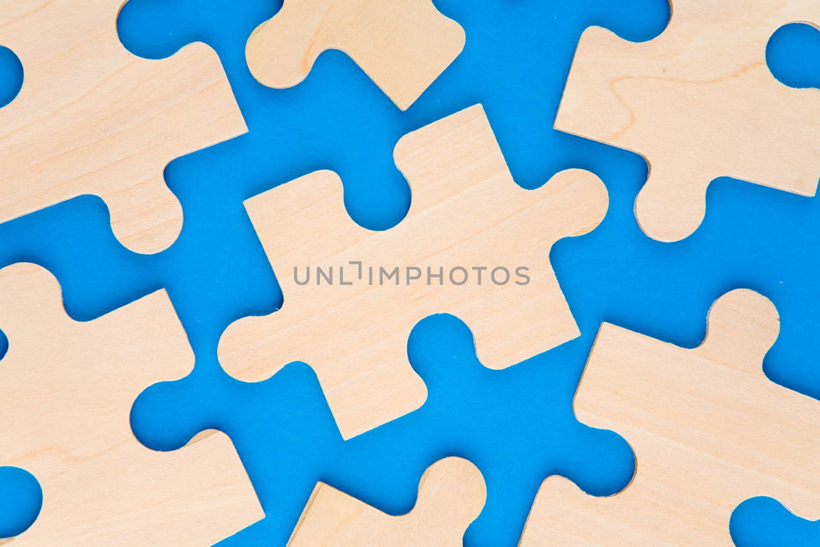 Wooden puzzle pieces on blue background