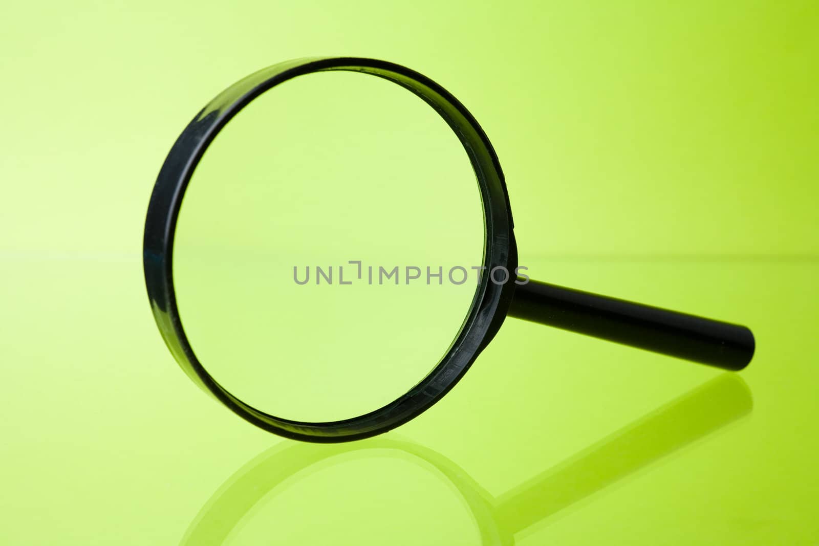 Magnifying glass on green background