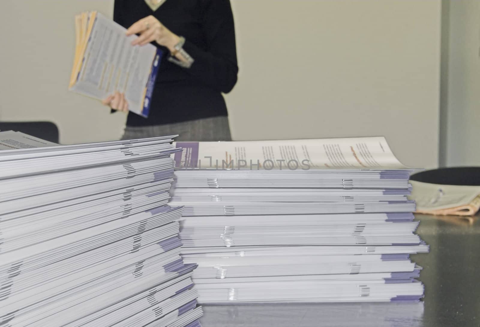 Piles of Handout Pamphlets and Woman in Background