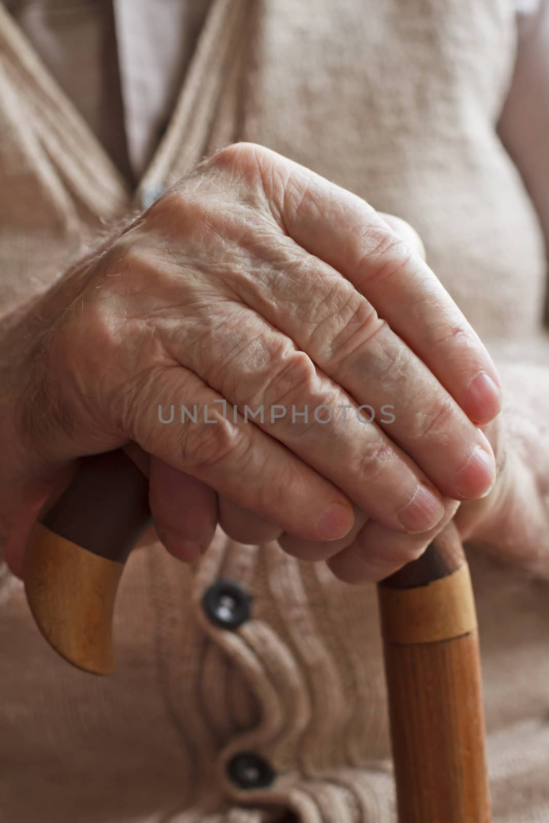 Hand of a senior man with a  cane by manaemedia