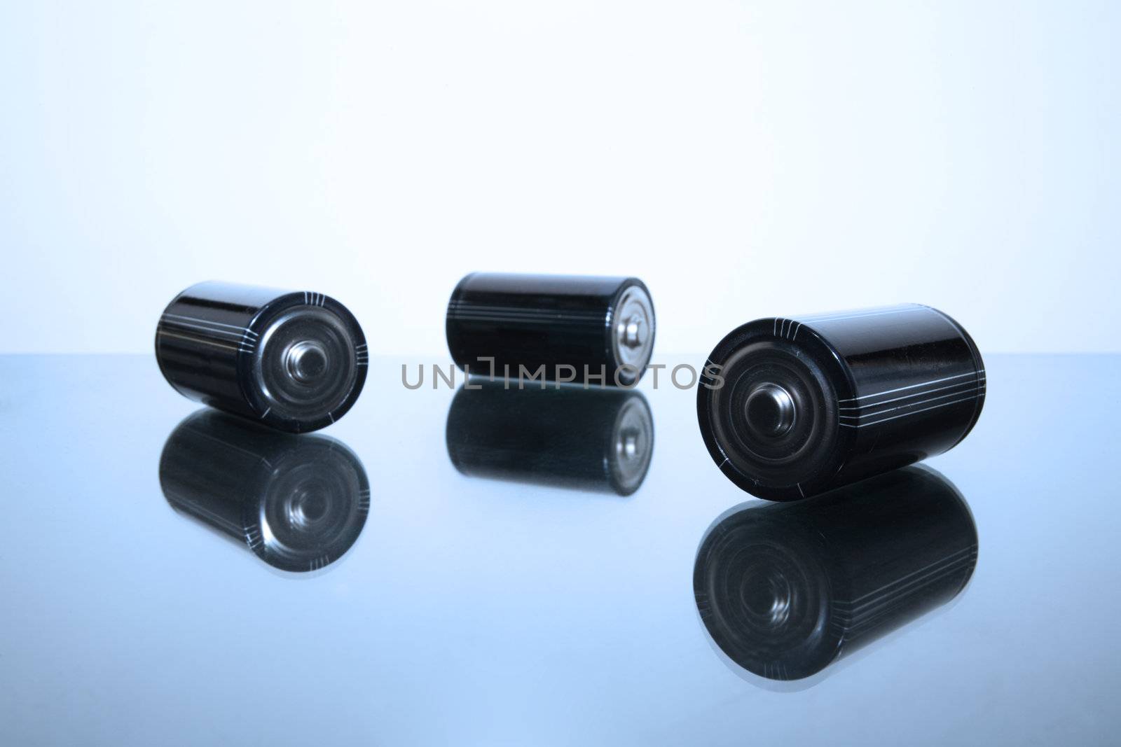 Three LR20 alkaline batteries on a reflective studio background