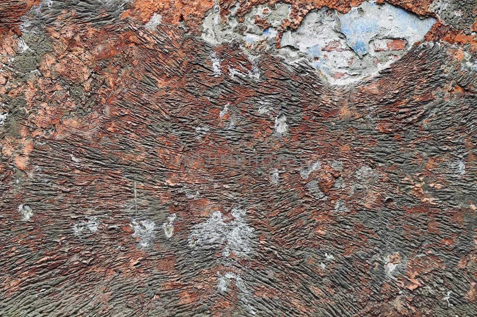 Red-colored corroded wall with surface ridges