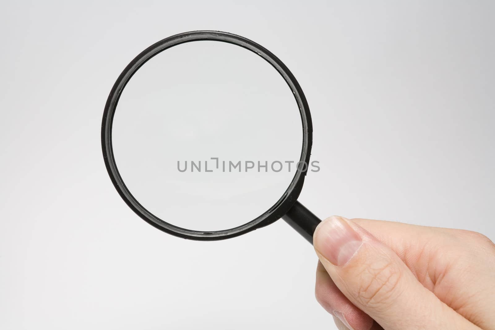 Magnifying glass in hand over white background