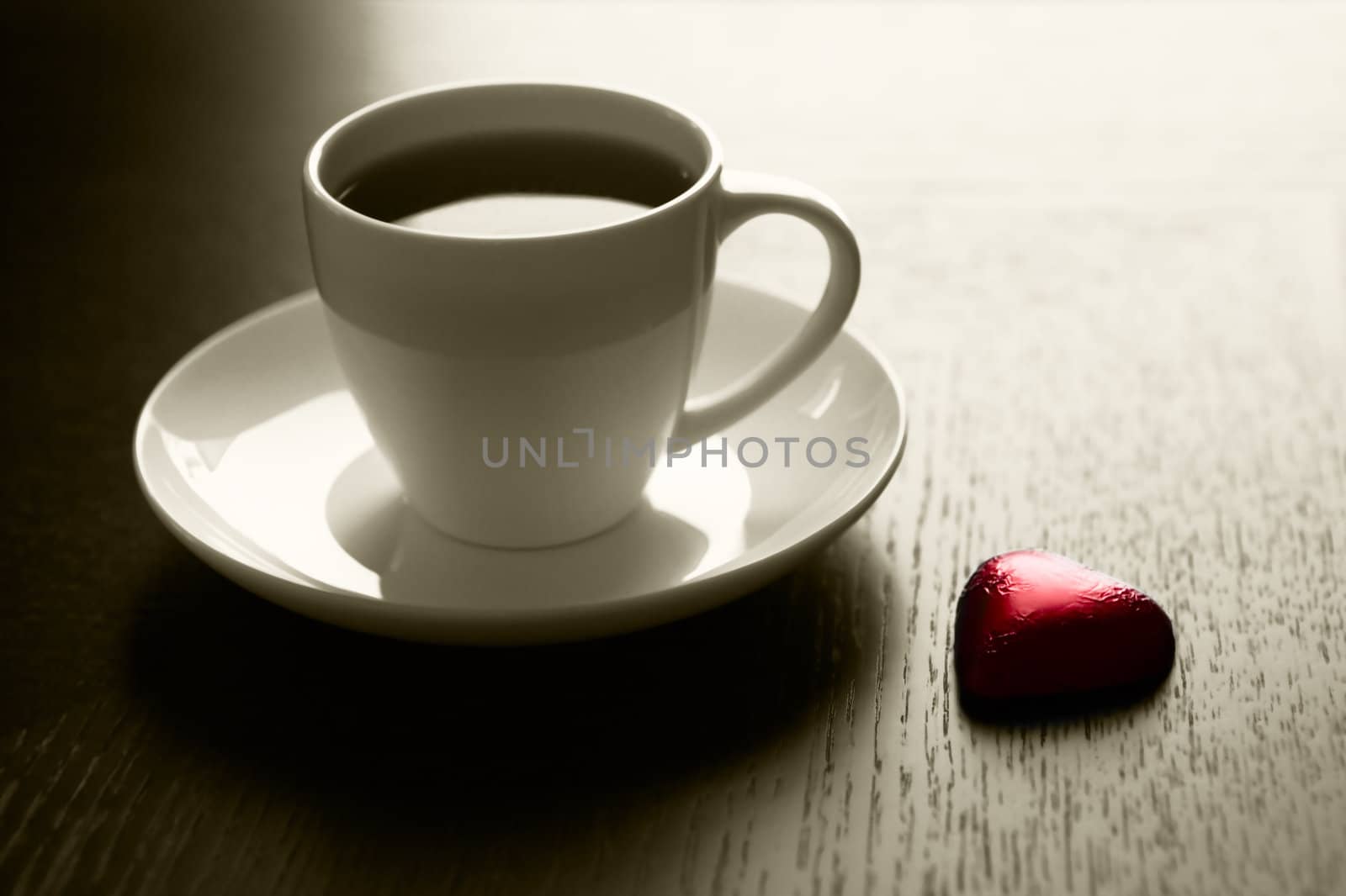 Cup of black coffee and a chocolate heart