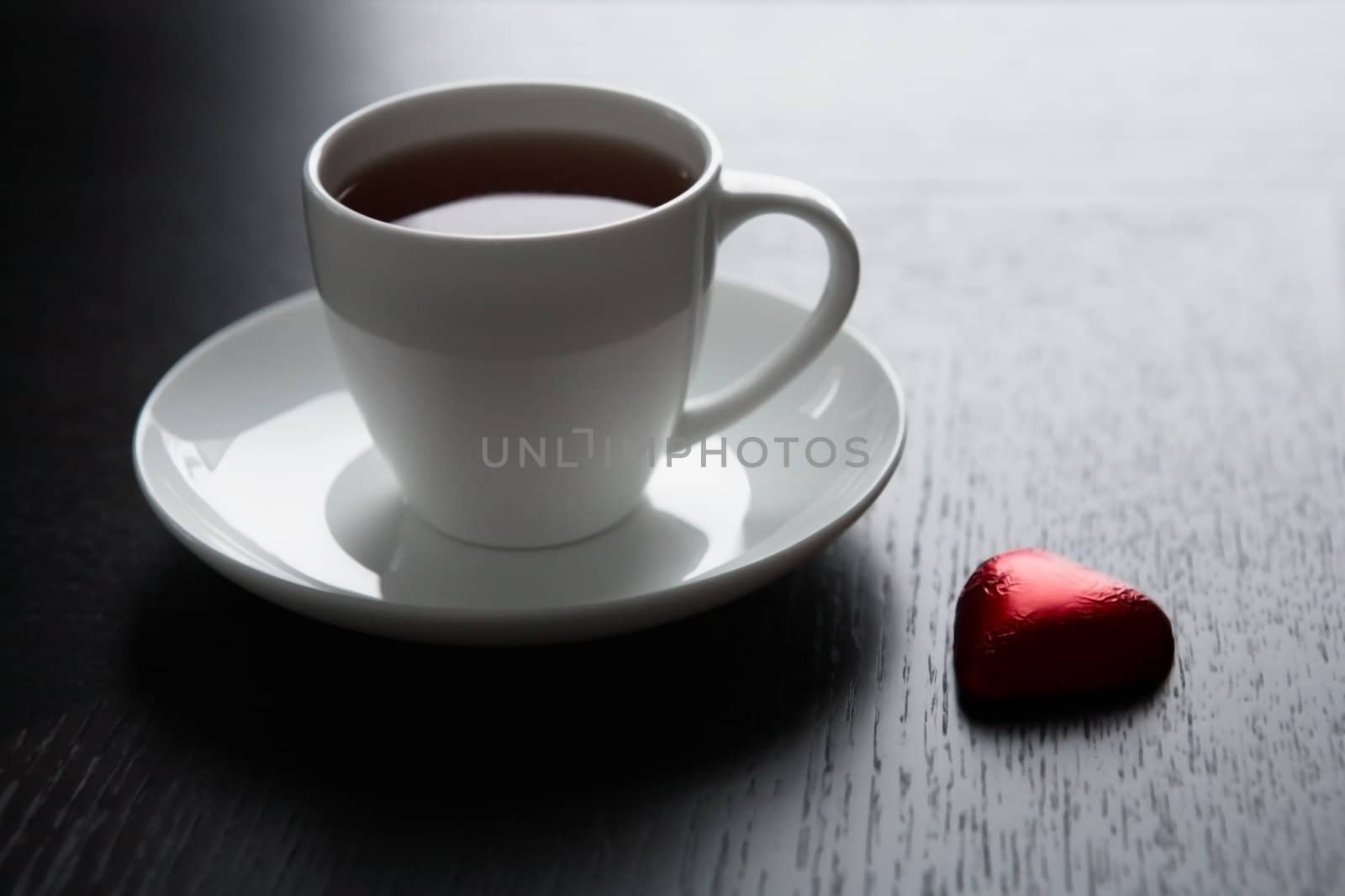 Cup of black coffee and a chocolate heart