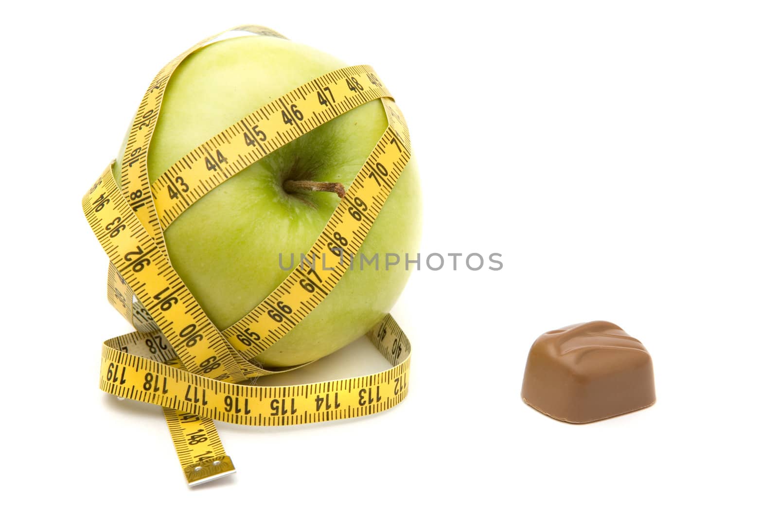 Apple imprisoned by a measuring tape versus tempting chocolate