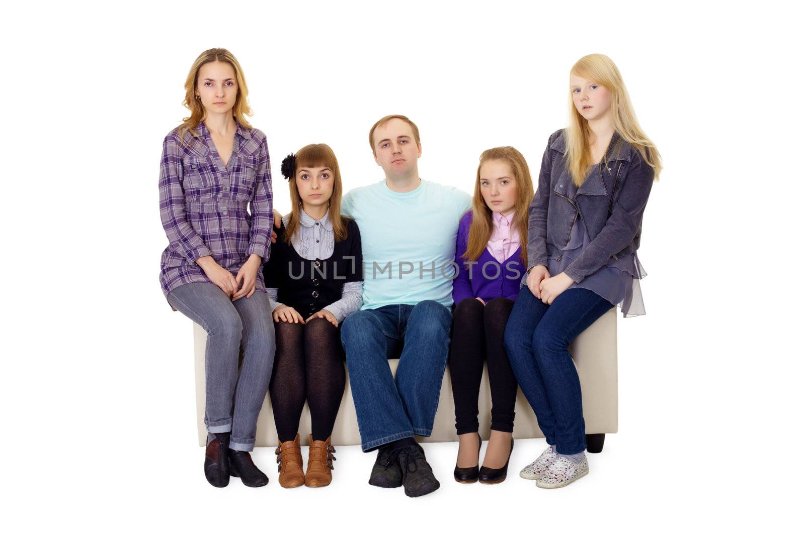An ordinary family with many children sitting on the couch