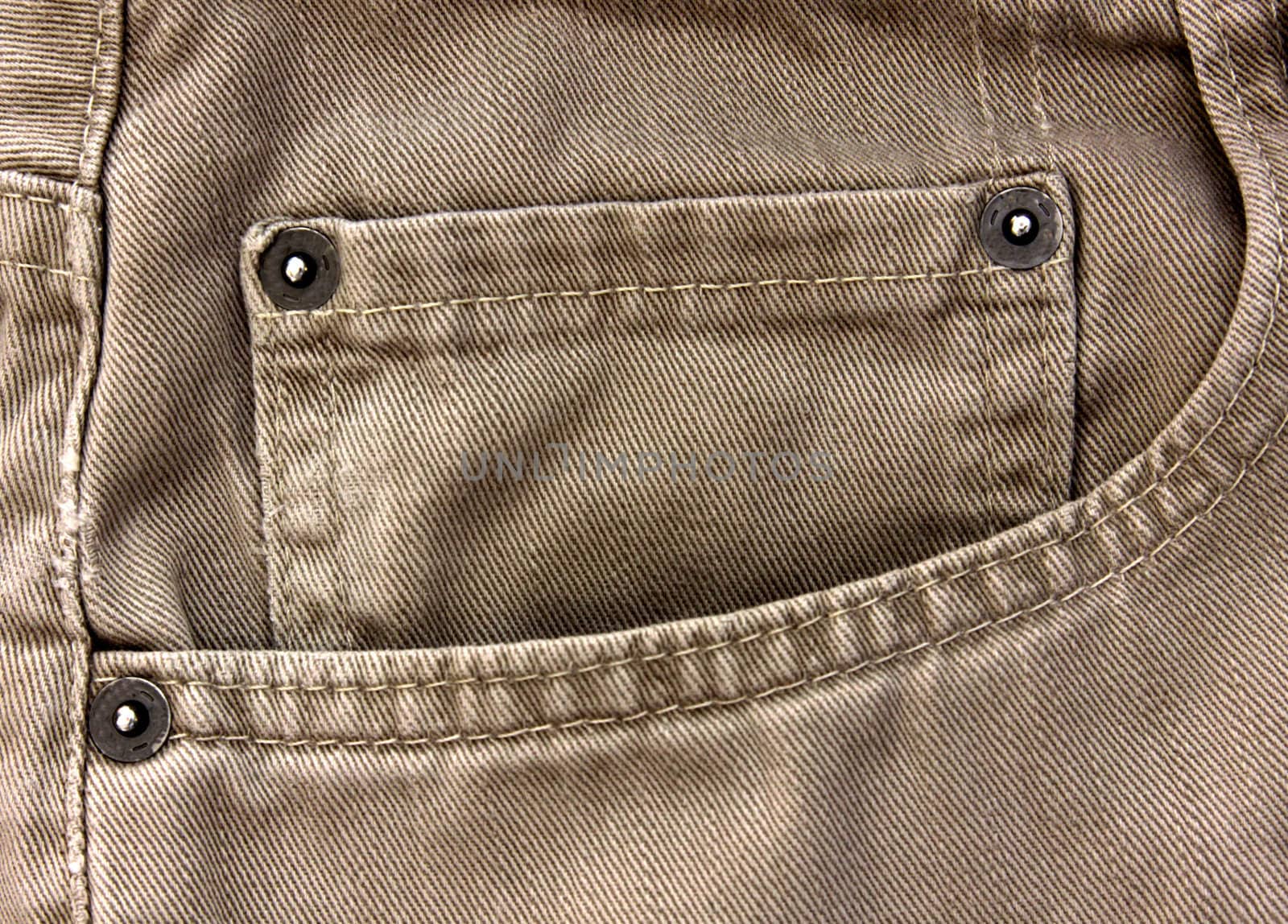 A close up of a beige jean pocket.