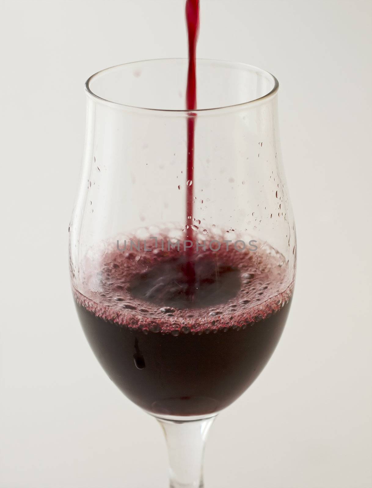 Red wine pouring in a big glass