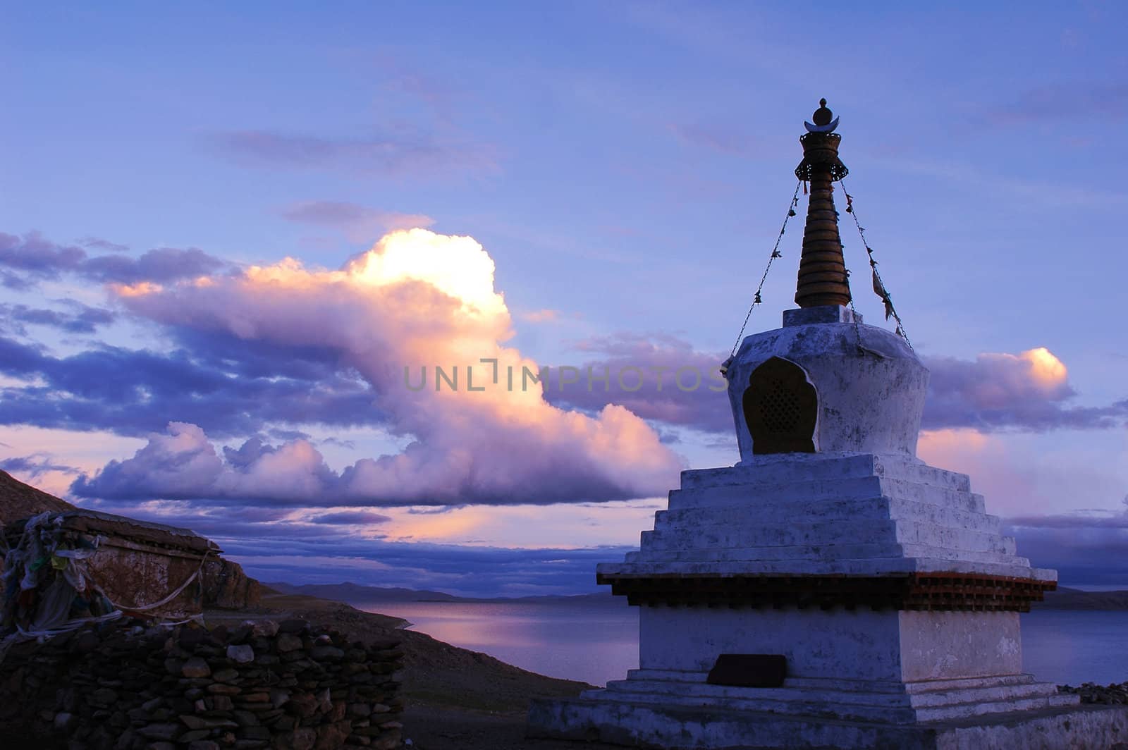 Landscape of a white stupa by a lake in Tibet