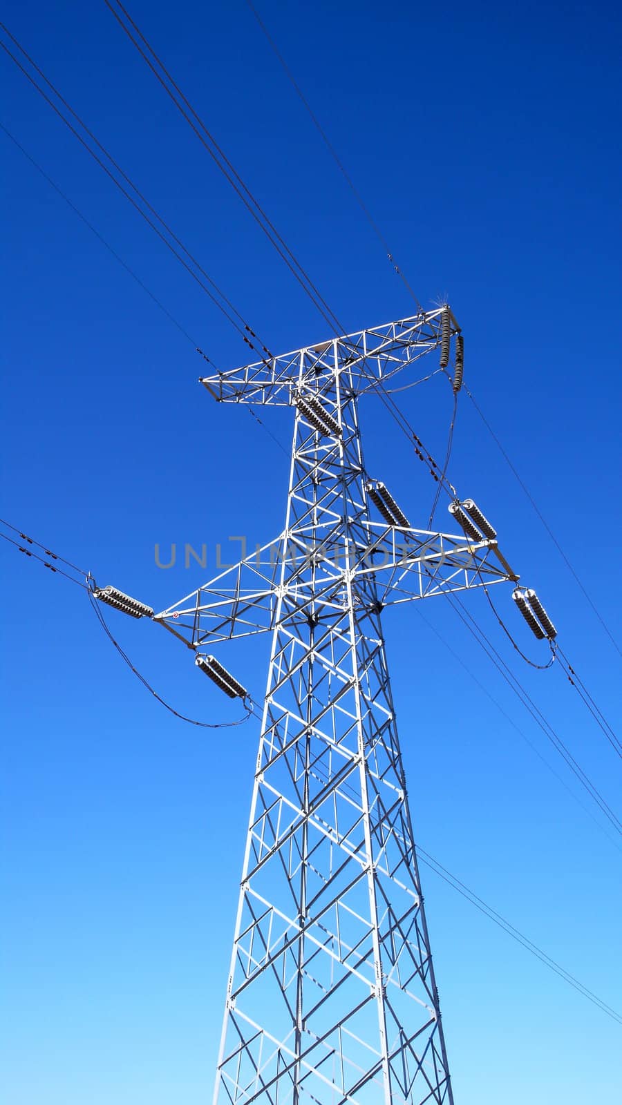 High voltage transmission lines with blue sky as background