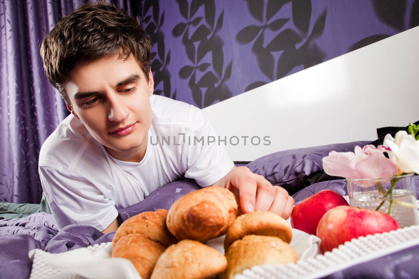 Male having breakfast in bed by vilevi