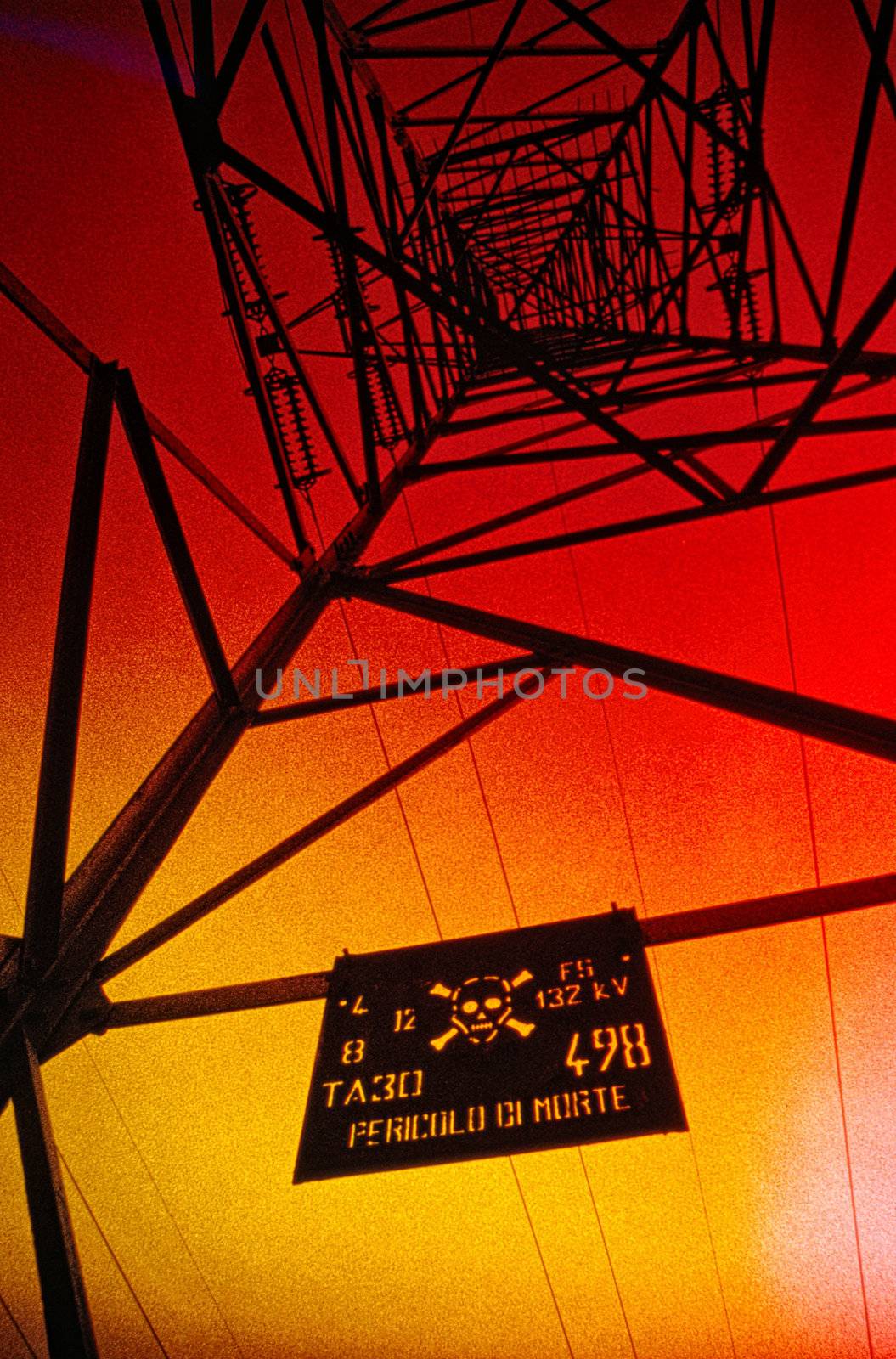 Dramatic view of a warning sign on an electricity pylon