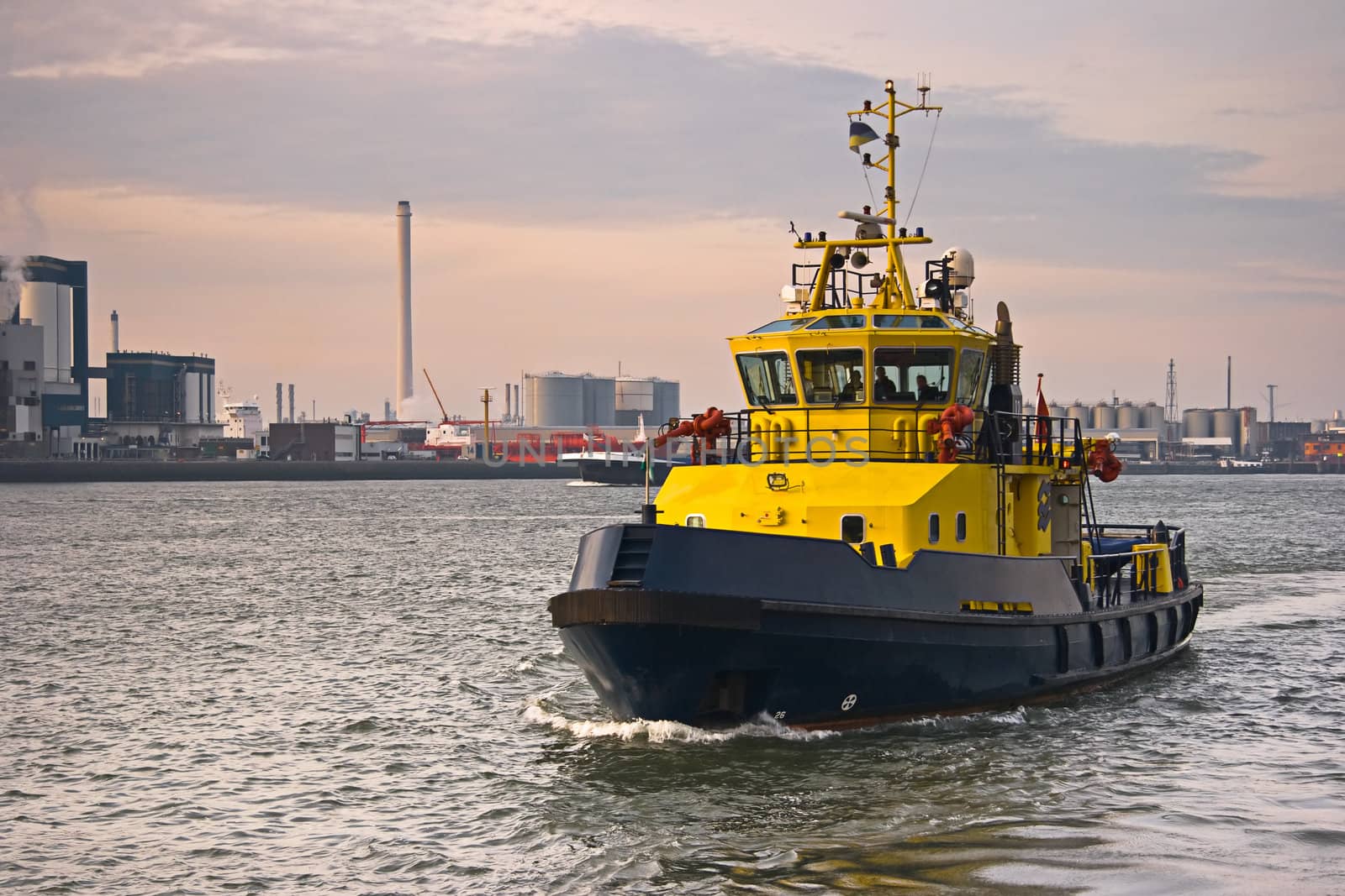 Tug on the river with industrial background 