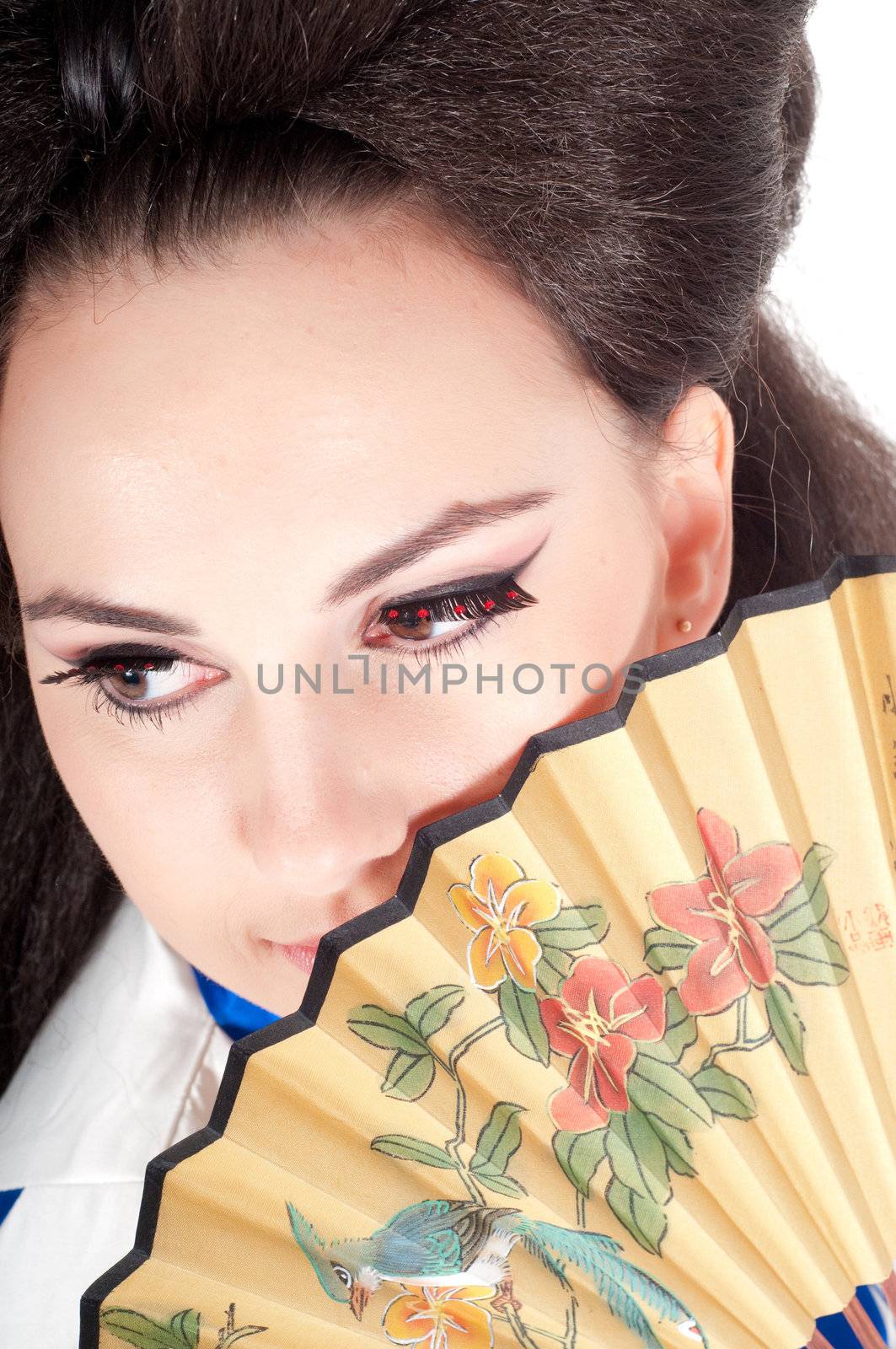 Portrait of the girl of the Asian appearance with a make-up under the geisha on a white background