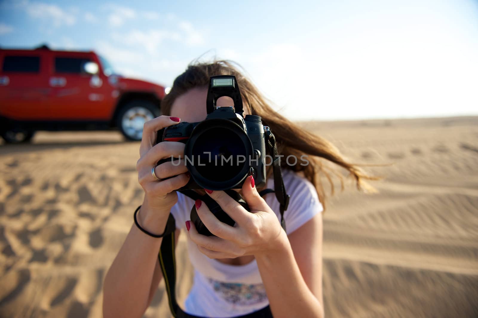 Pretty young woman taking photo in the Dubai Desert, United Arab Emirates
