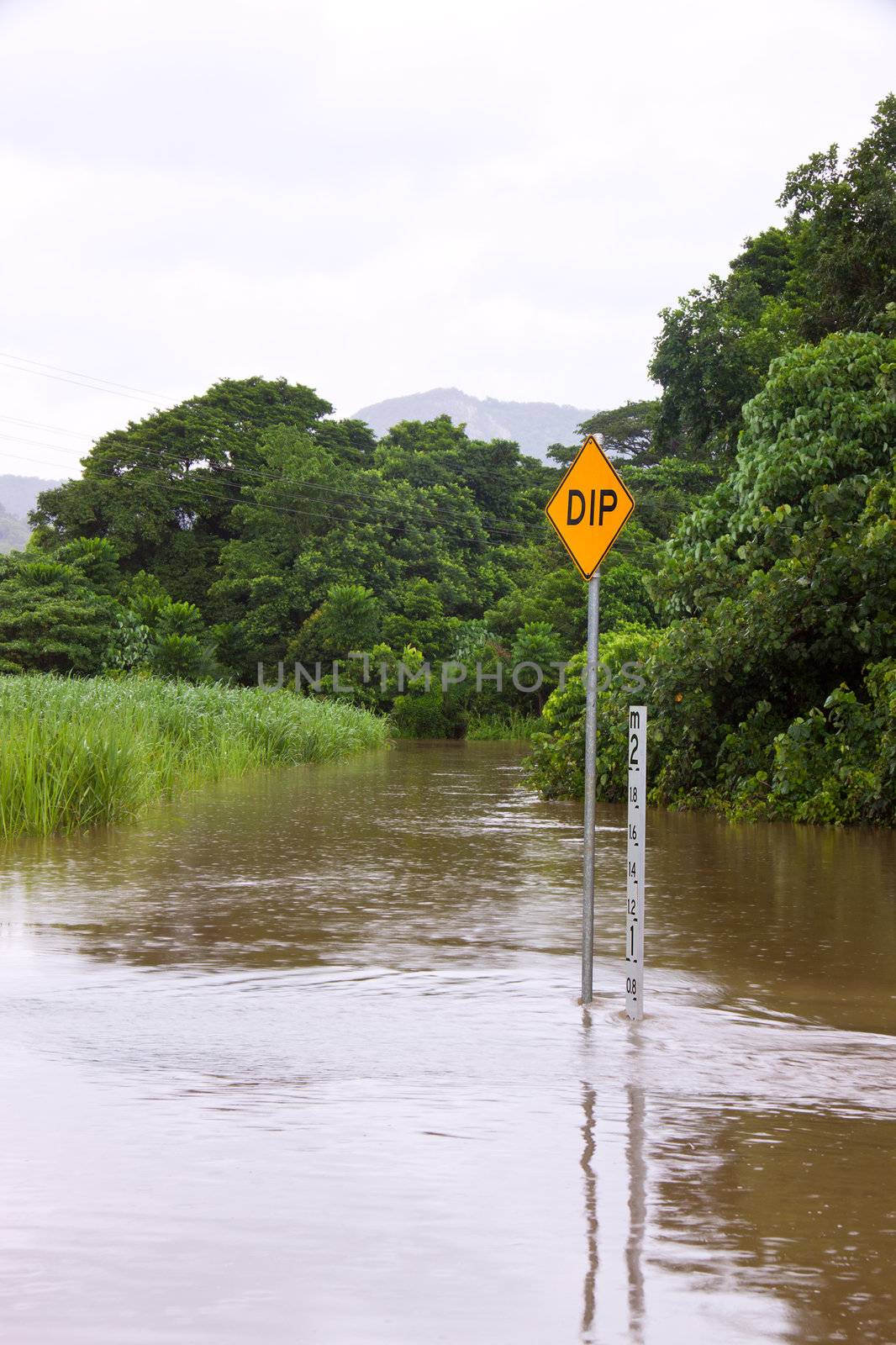 Flooded road with depth indicators in Queensland, Australia by Jaykayl