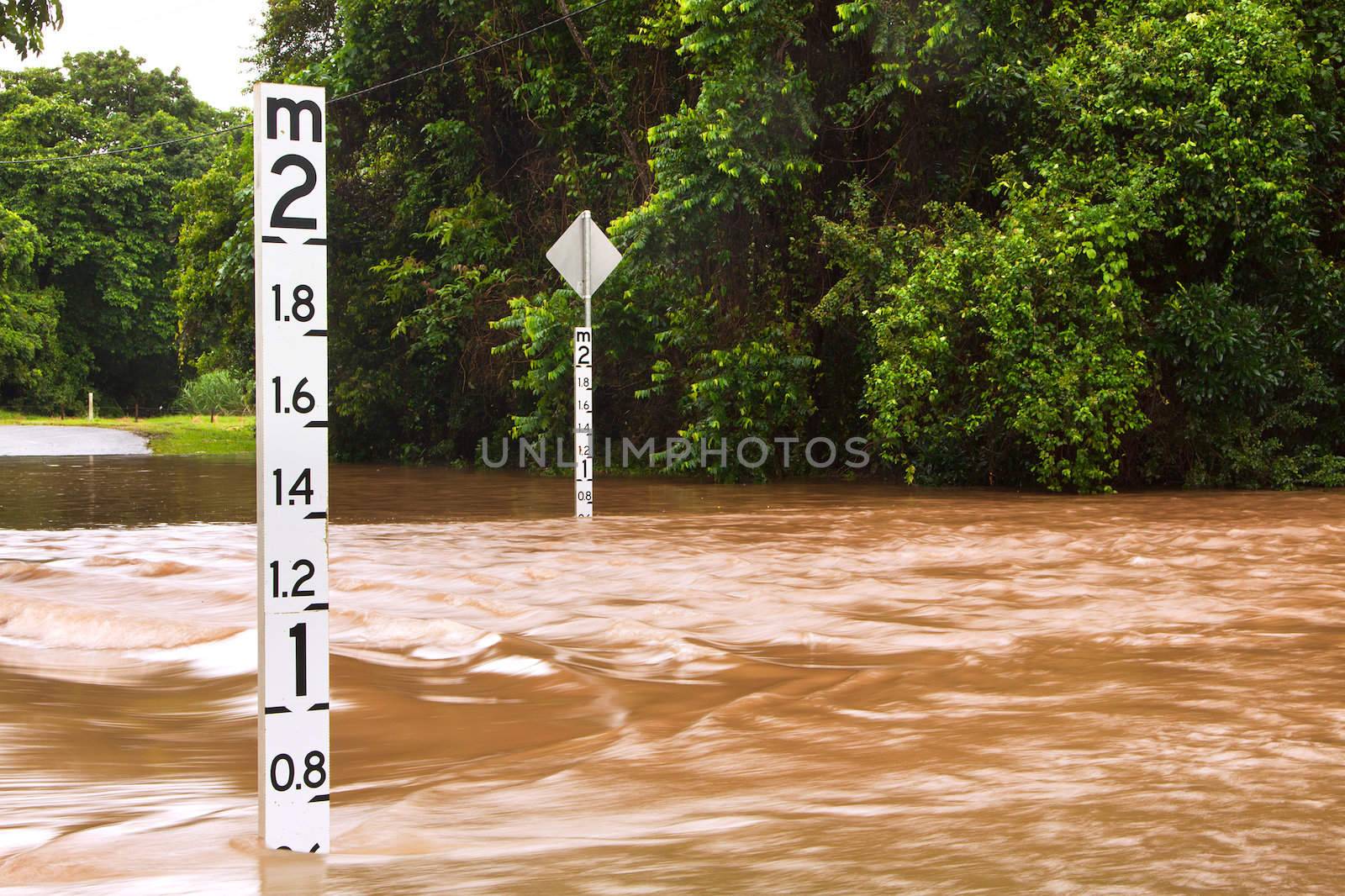 Flooded road with depth indicators in Queensland, Australia by Jaykayl