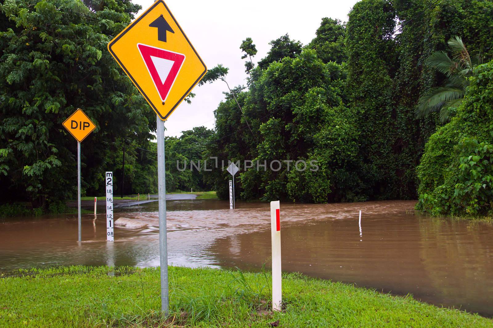 Flooded road with depth indicators and give way sign in Queensla by Jaykayl