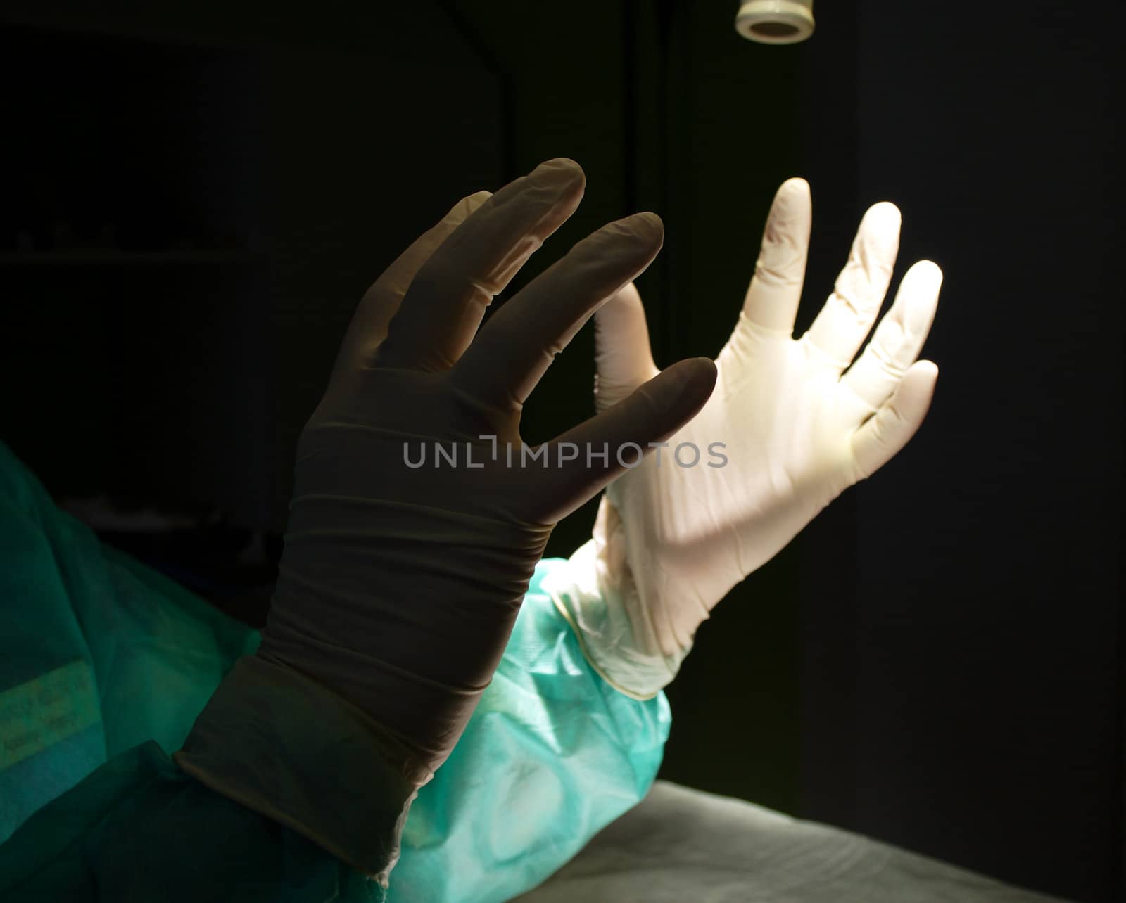 Surgeon holding up hands in protective gloves photo