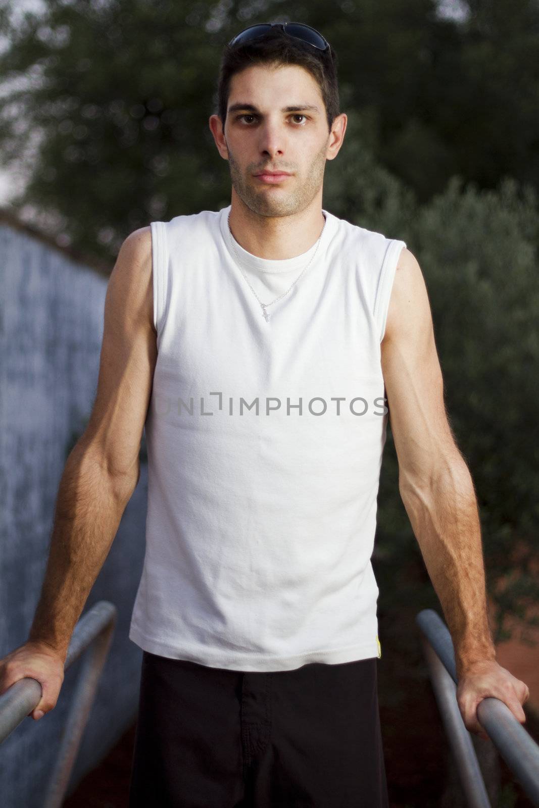 Close view of a young man doing exercise on a park.