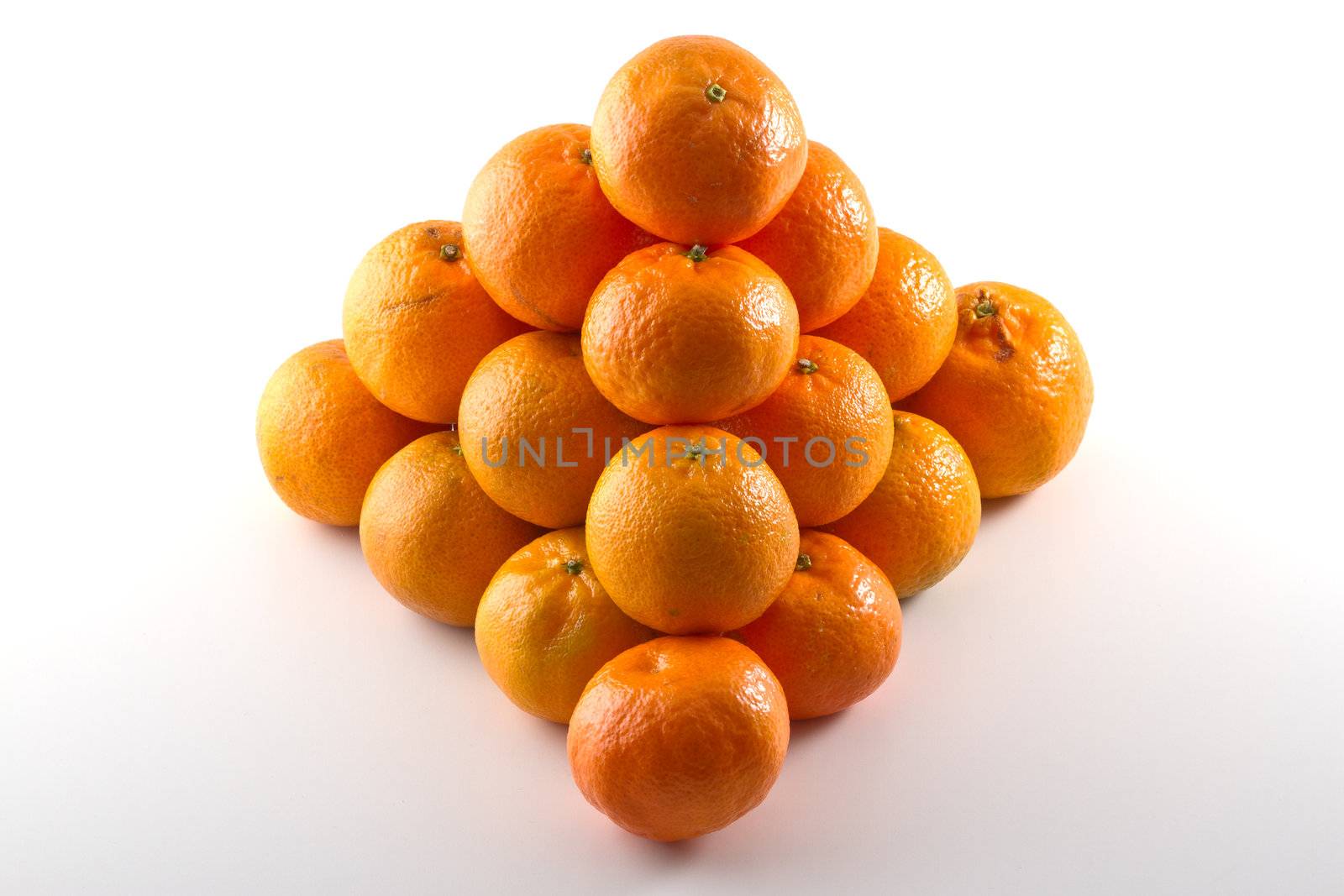 Clementines arranged in a pyramid shape isolated on white background