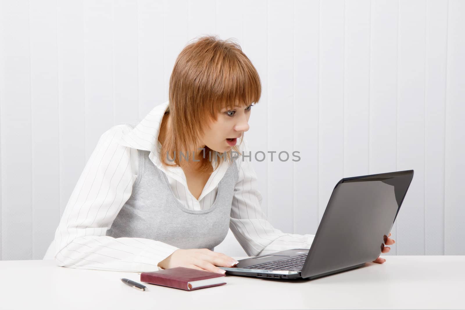 attractive girl with surprise stares at the monitor laptop
