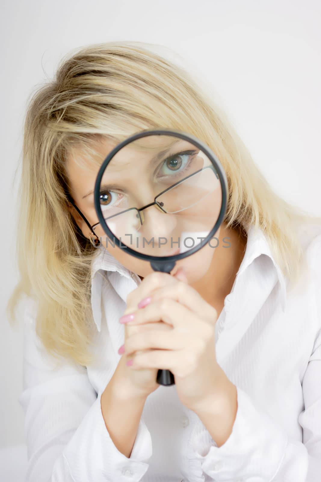 girl with a magnifying glass on a light background
