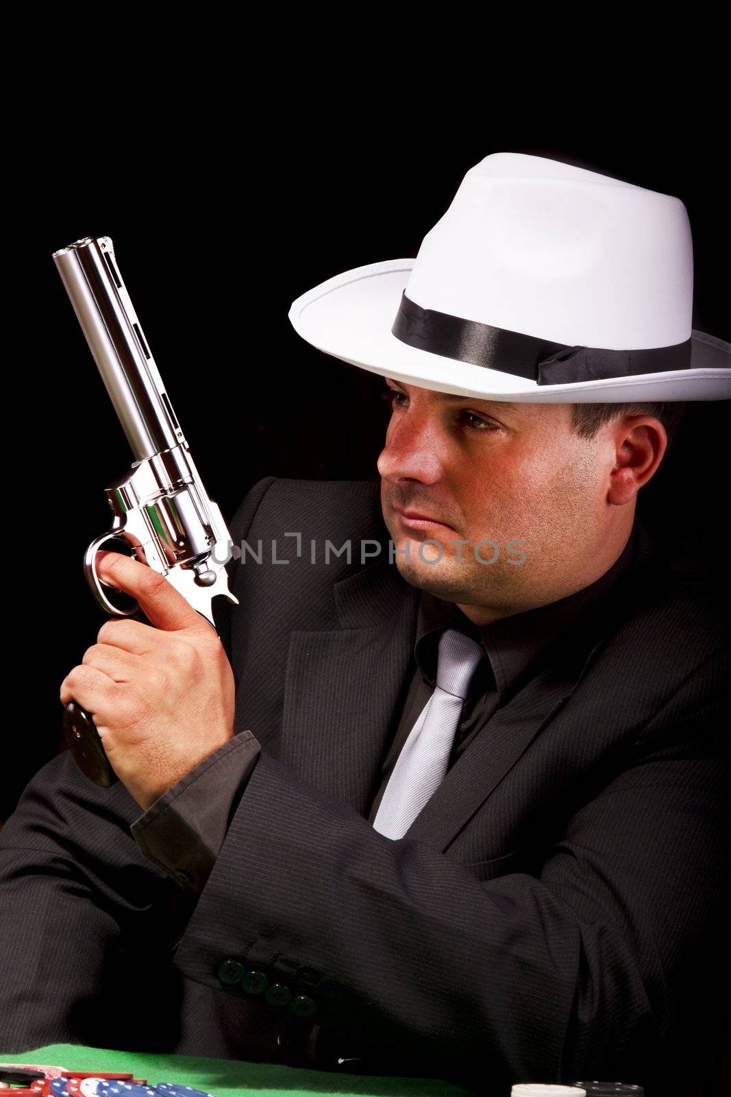 View of a dark suit gangster man holding a gun.
