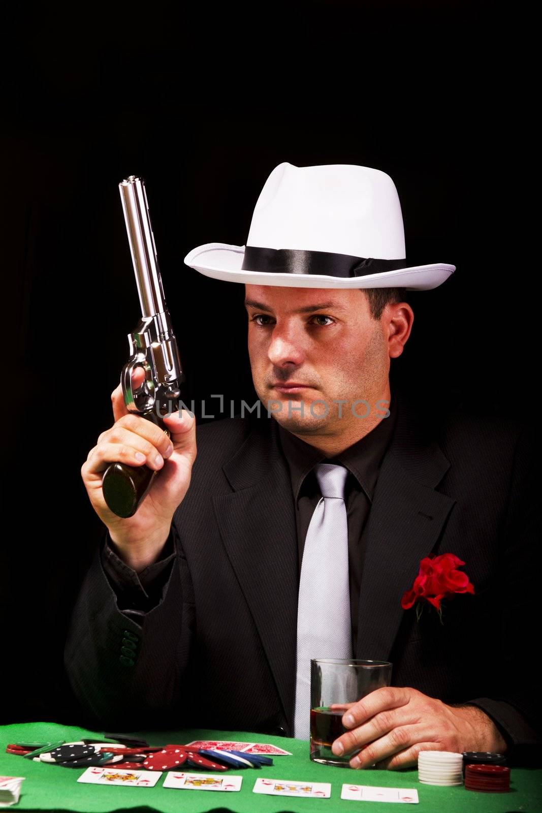 View of a dark suit gangster man holding a gun.