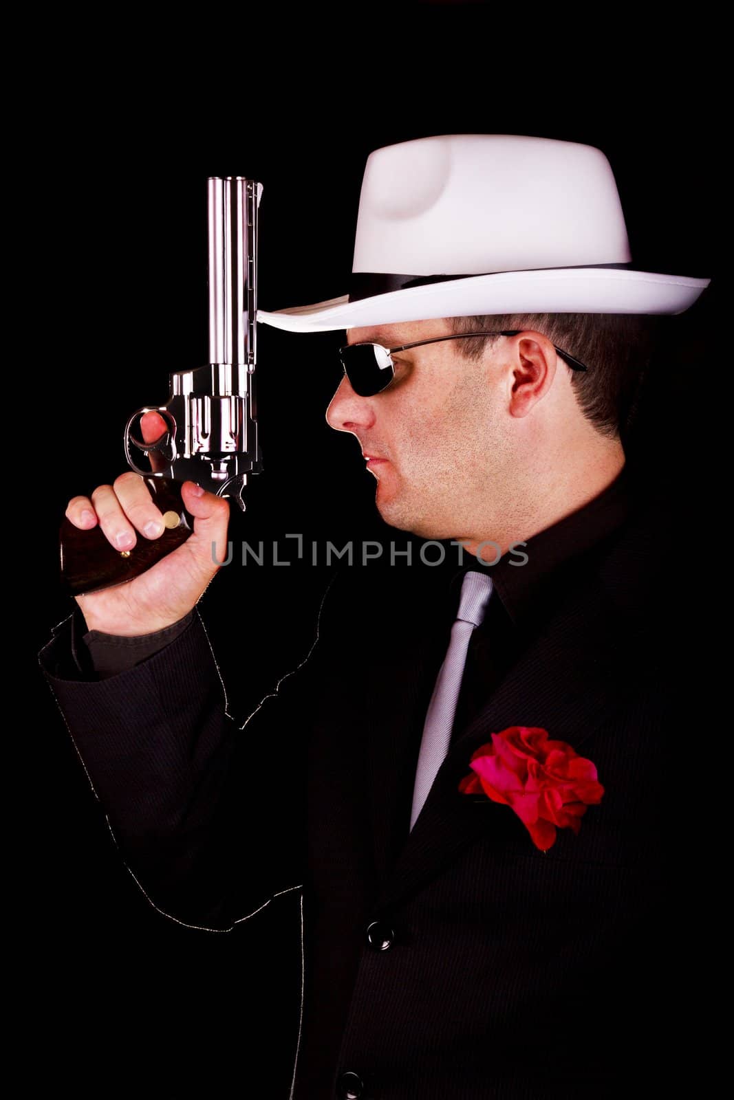 View of a dark suit gangster man holding a gun.