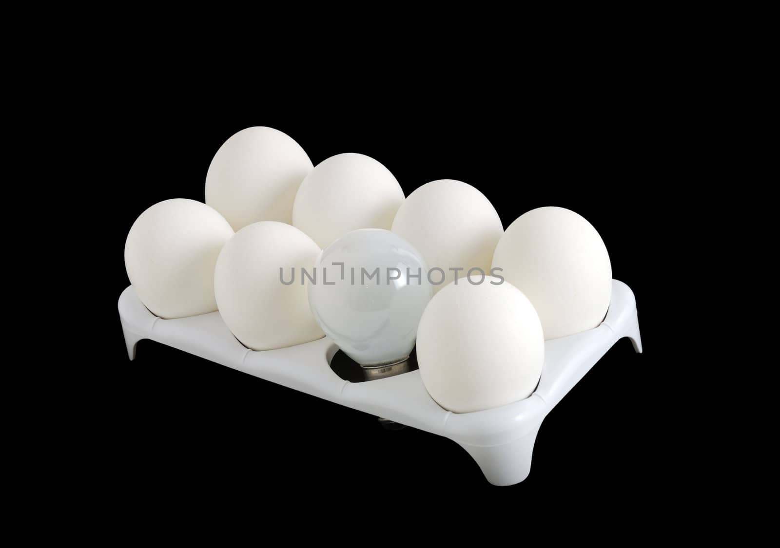 Carton with white eggs and small bulb lamp on black background