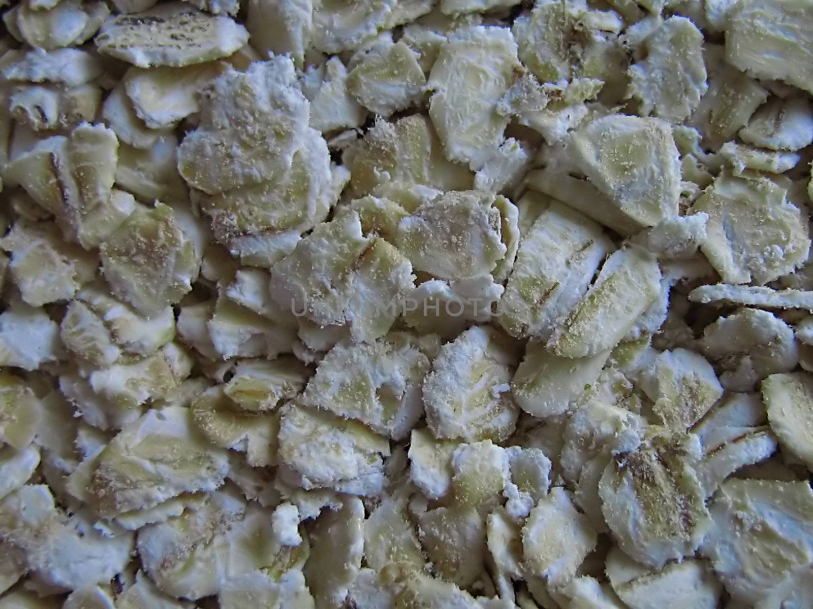 A photograph of uncooked oatmeal detailing its texture.
