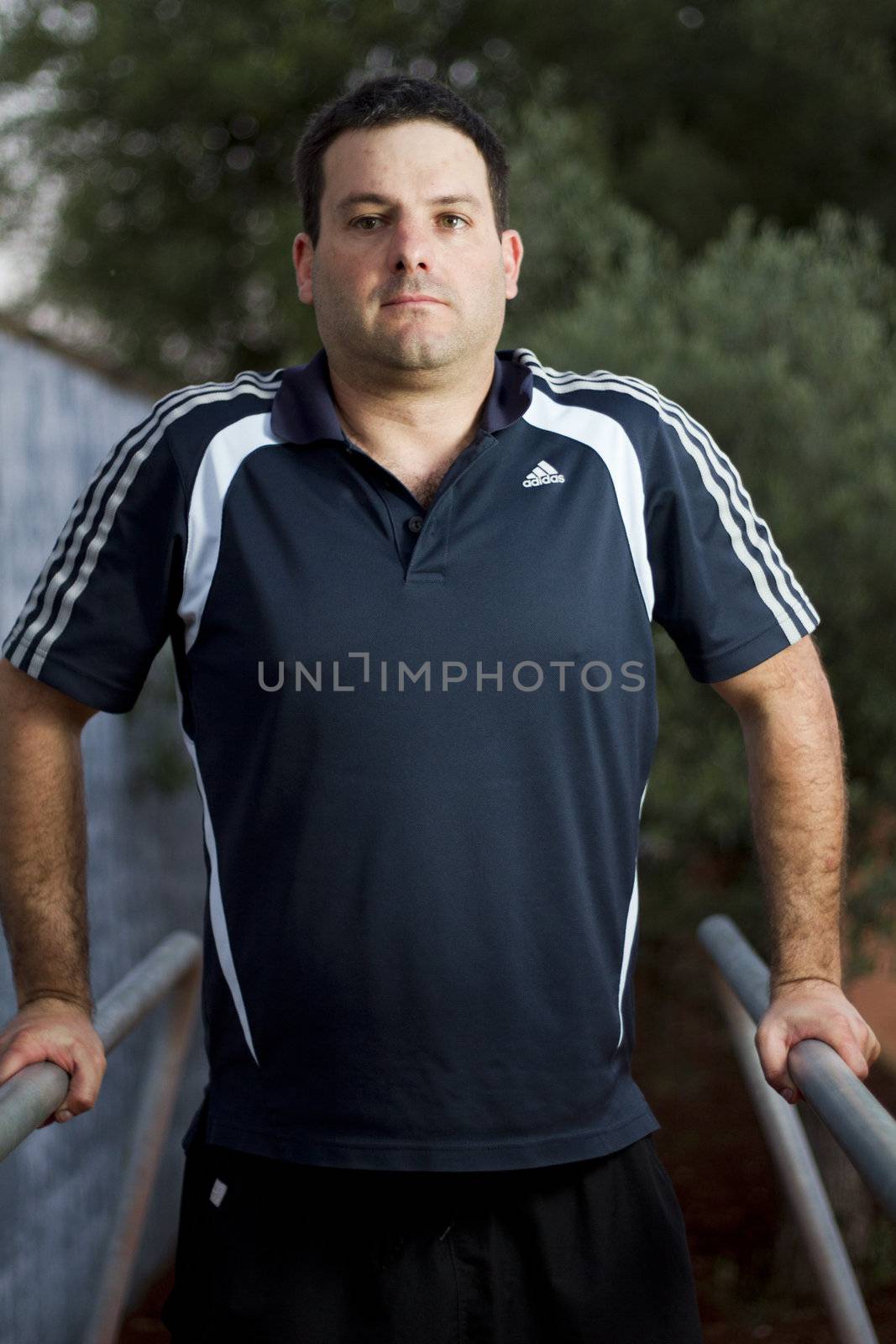 Close view of a young man doing exercise on a park.