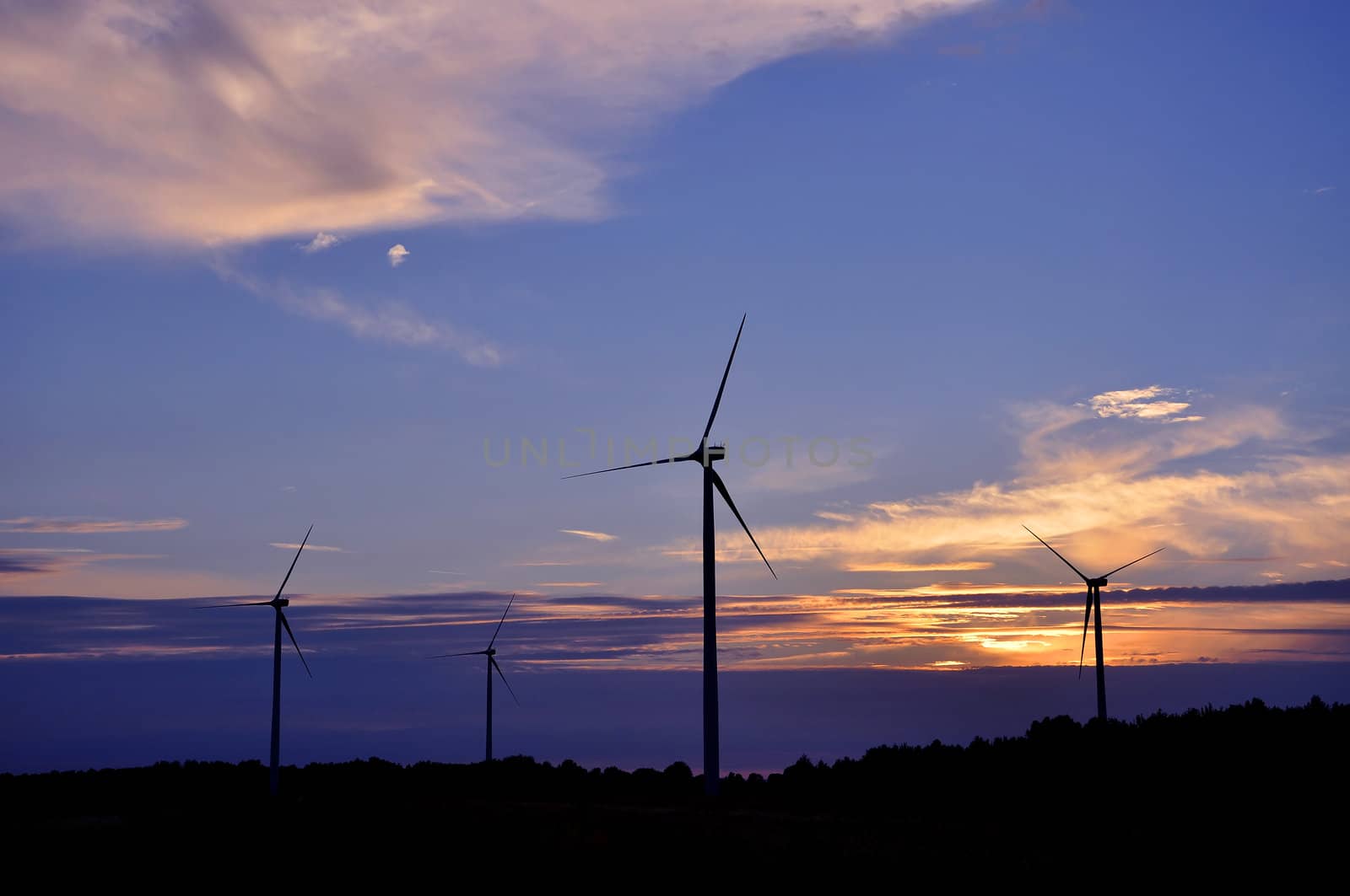 Wind turbine farm over sunset