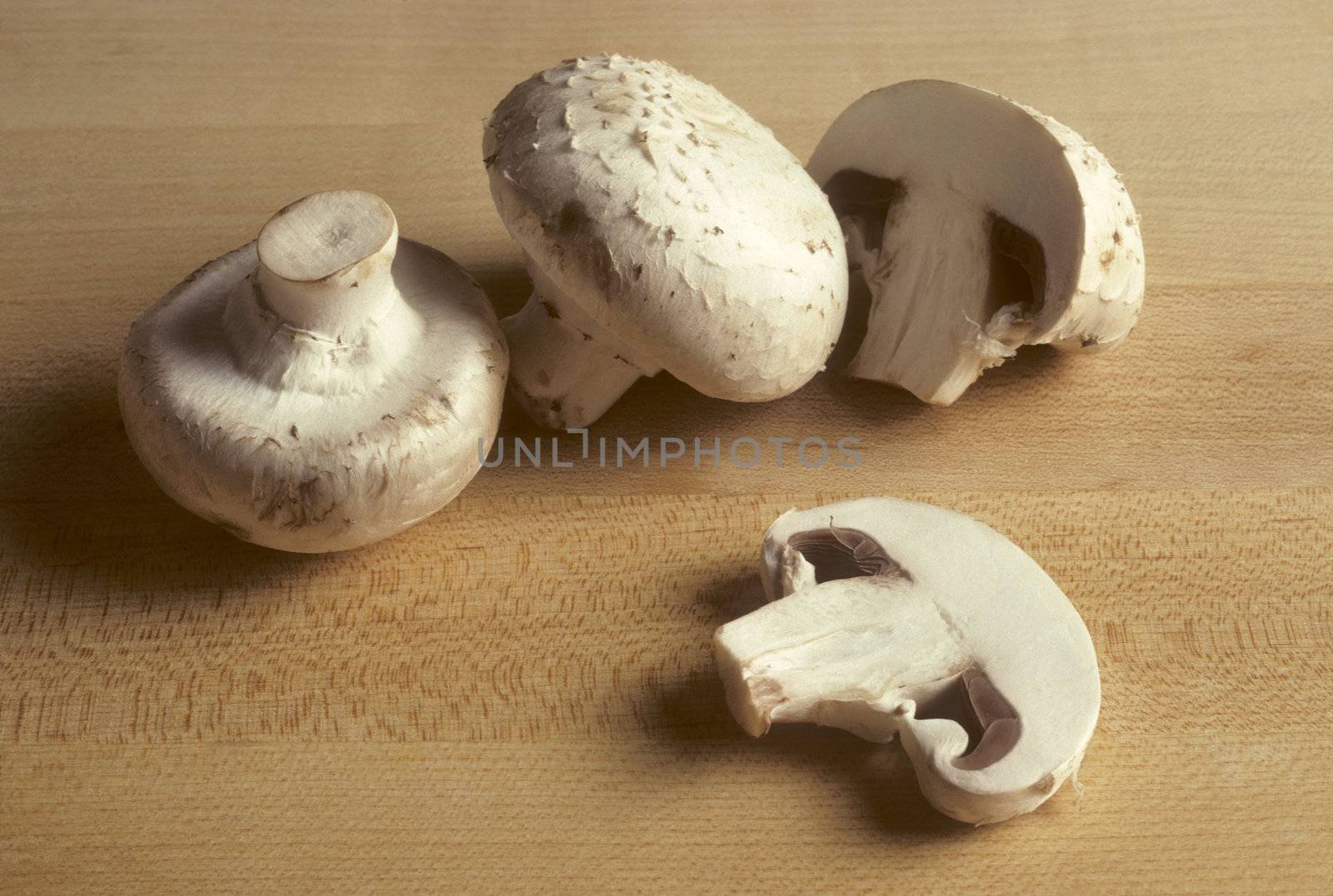 White mushrooms on a wooden cutting board