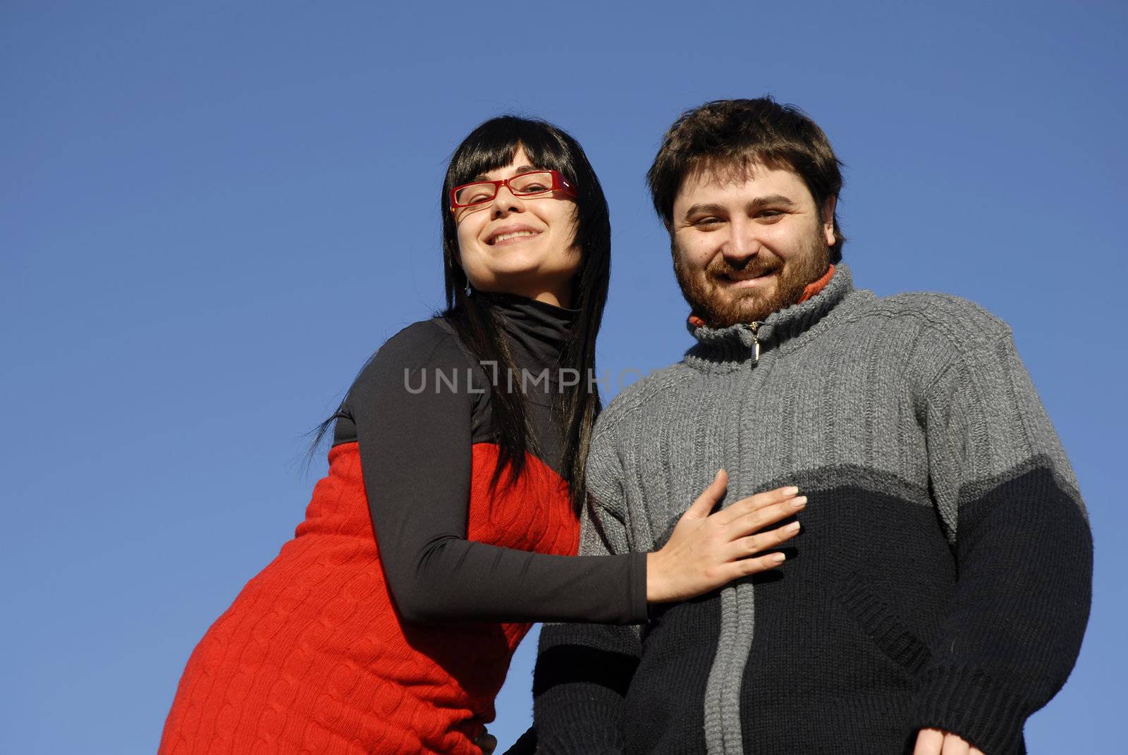 young happy couple with the sky as background
