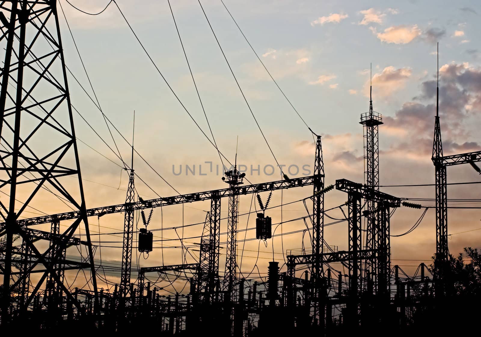 Electric substation on a background of the coming sun