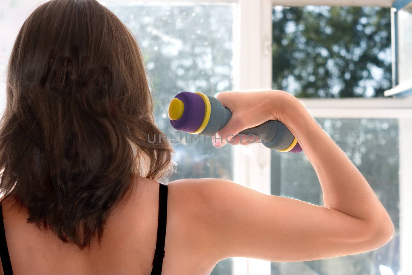 The woman engaged in gymnastics at a window