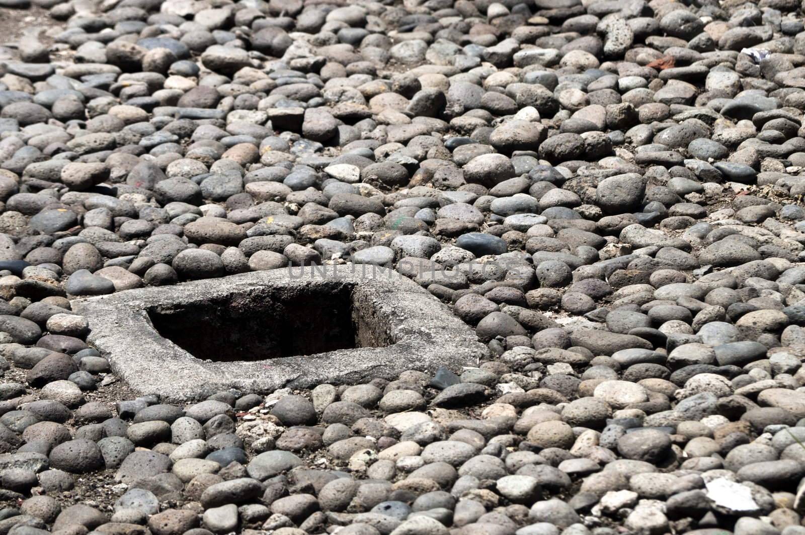 Deep Hole in a ground on shingle floor