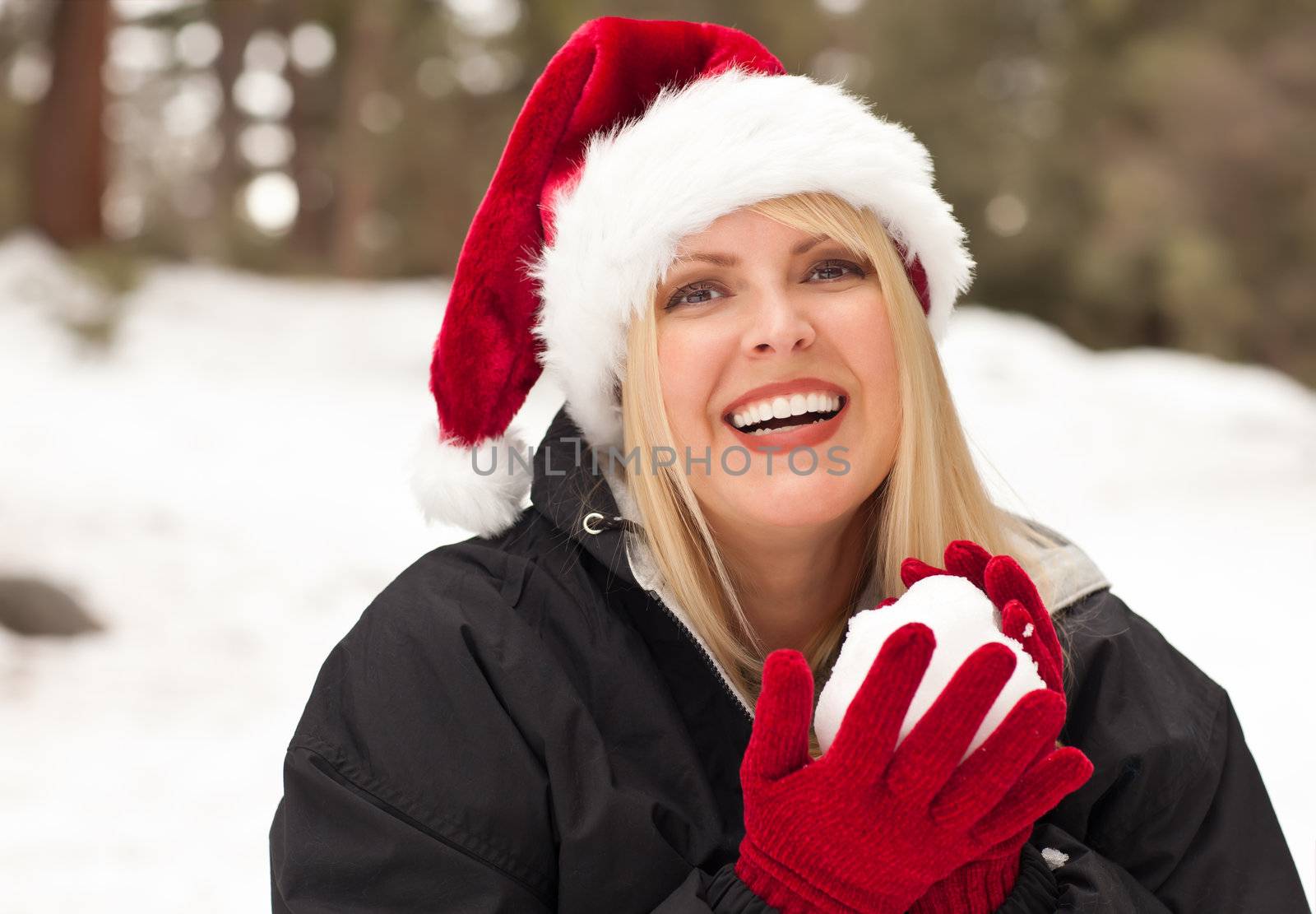 Attractive Santa Hat Wearing Blond Woman Having Fun in The Snow on a Winter Day.