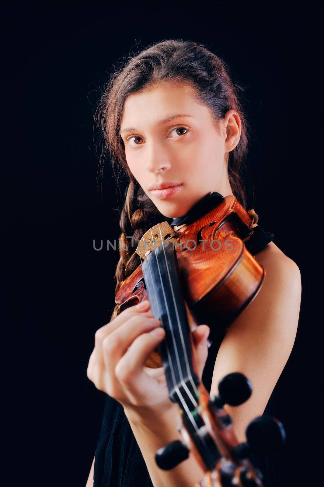 Young woman holding a violin. Isolated on the black background