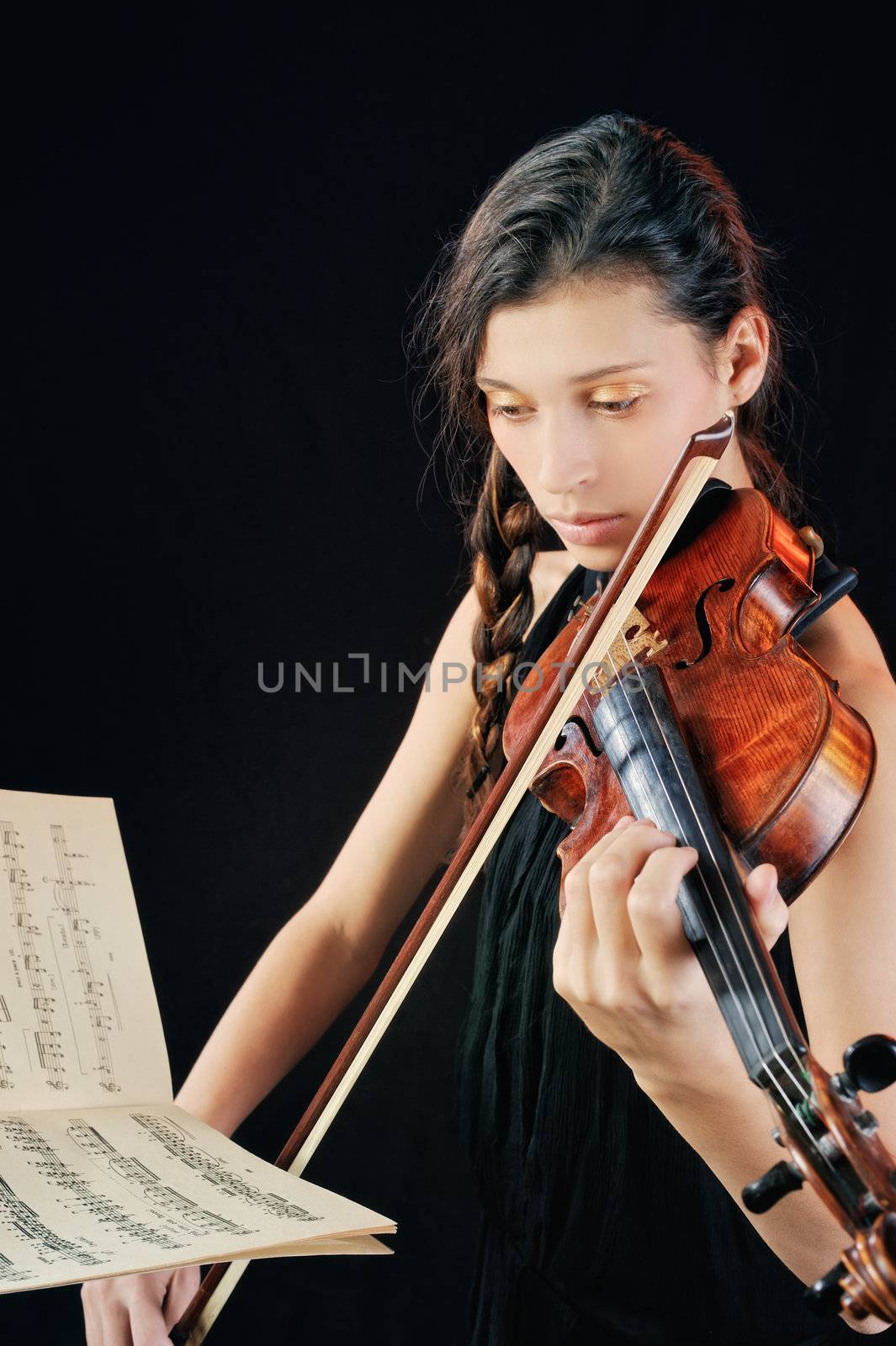 A young woman playing a violin on notes