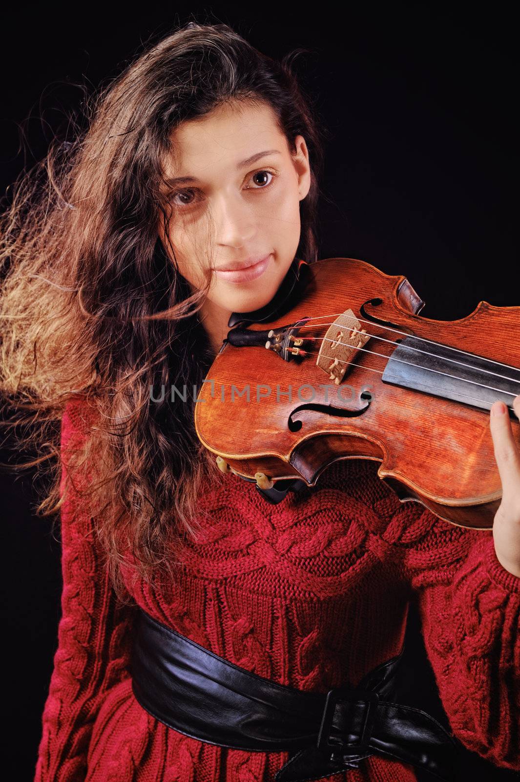 Young woman holding a violin. Isolated on the black background