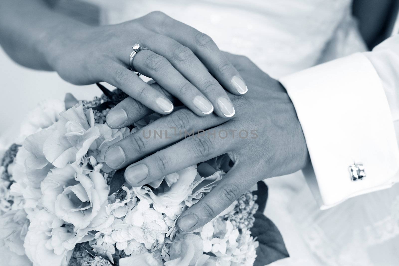 Hand of the groom and the bride with wedding bouquet
