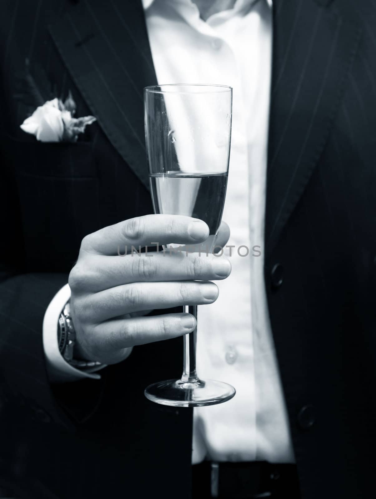 Glass of champagne in a hand of the groom