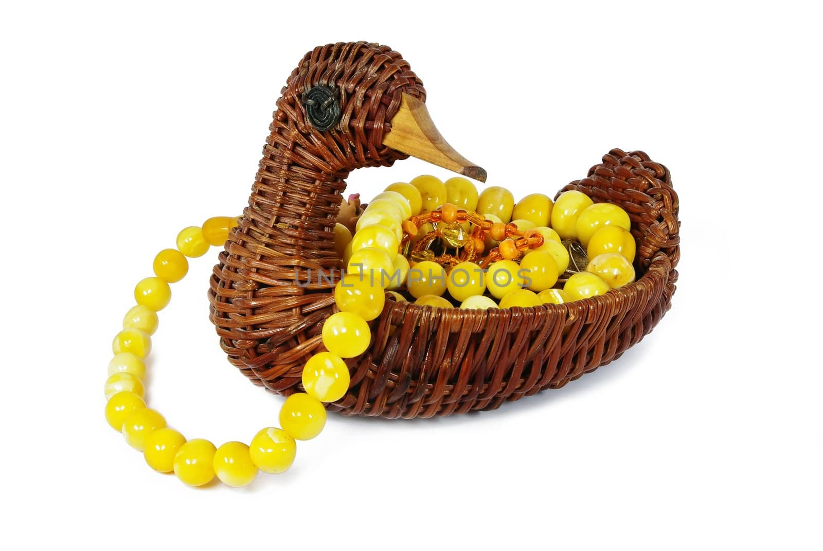 Wicker container in form of duck with amber beads on white background