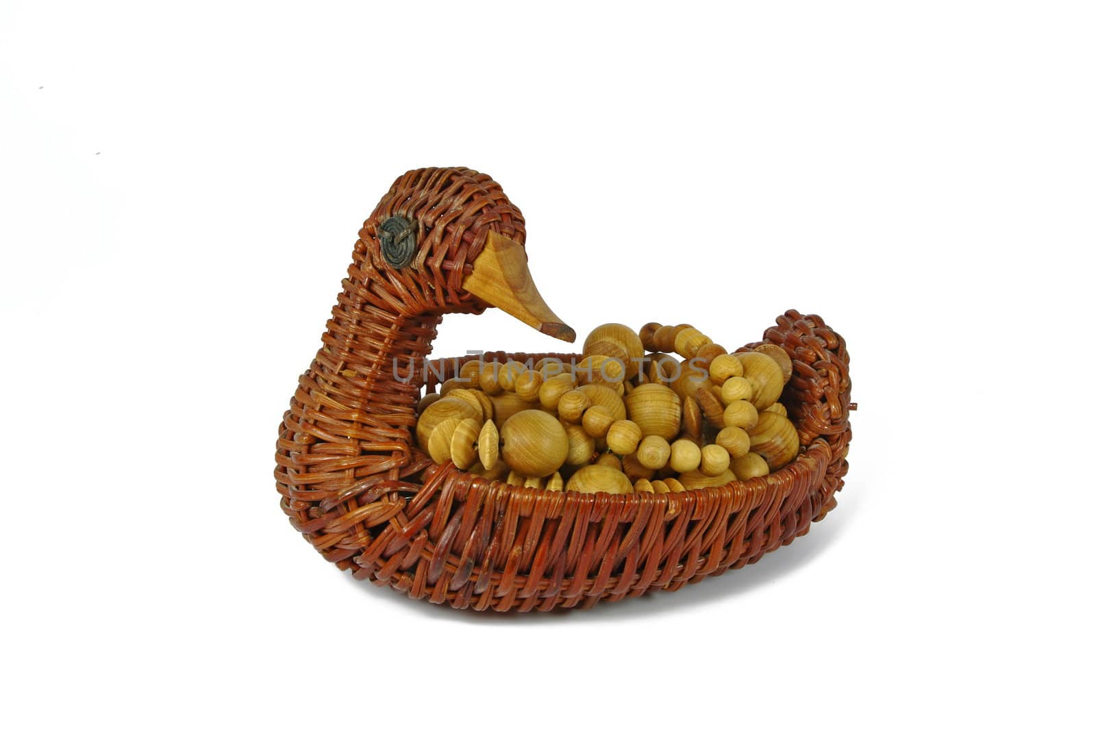 Wicker container in form of duck with wooden beads on white background
