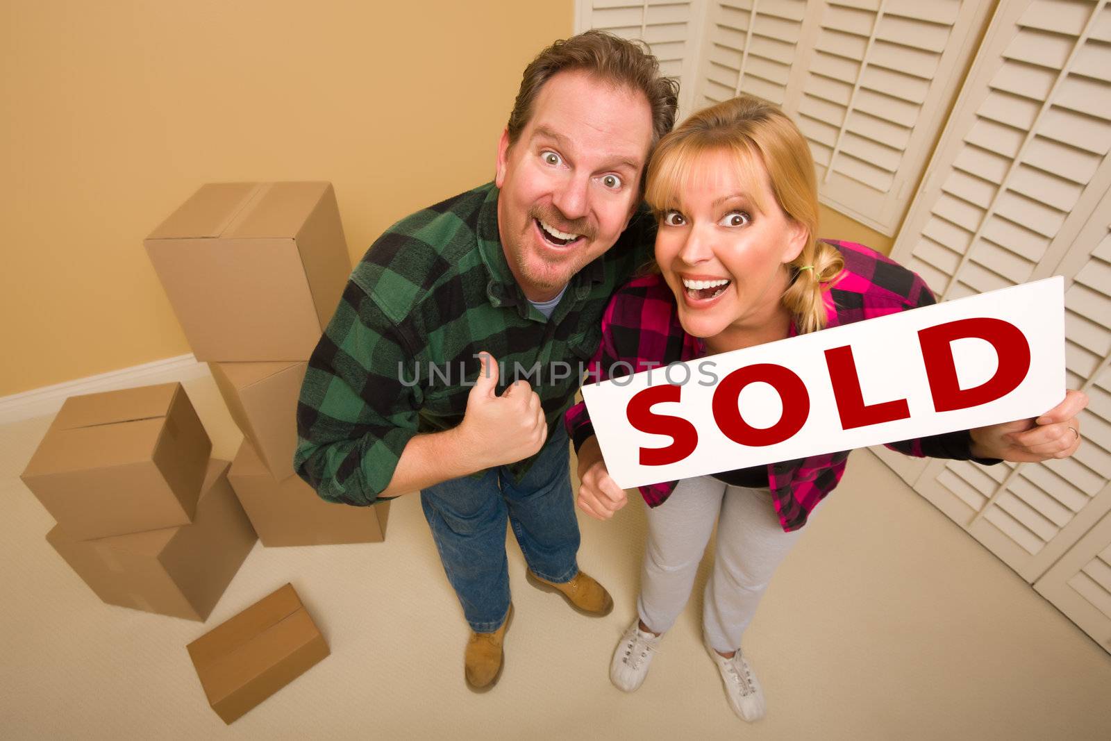 Goofy Couple Holding Sold Sign Surrounded by Boxes by Feverpitched