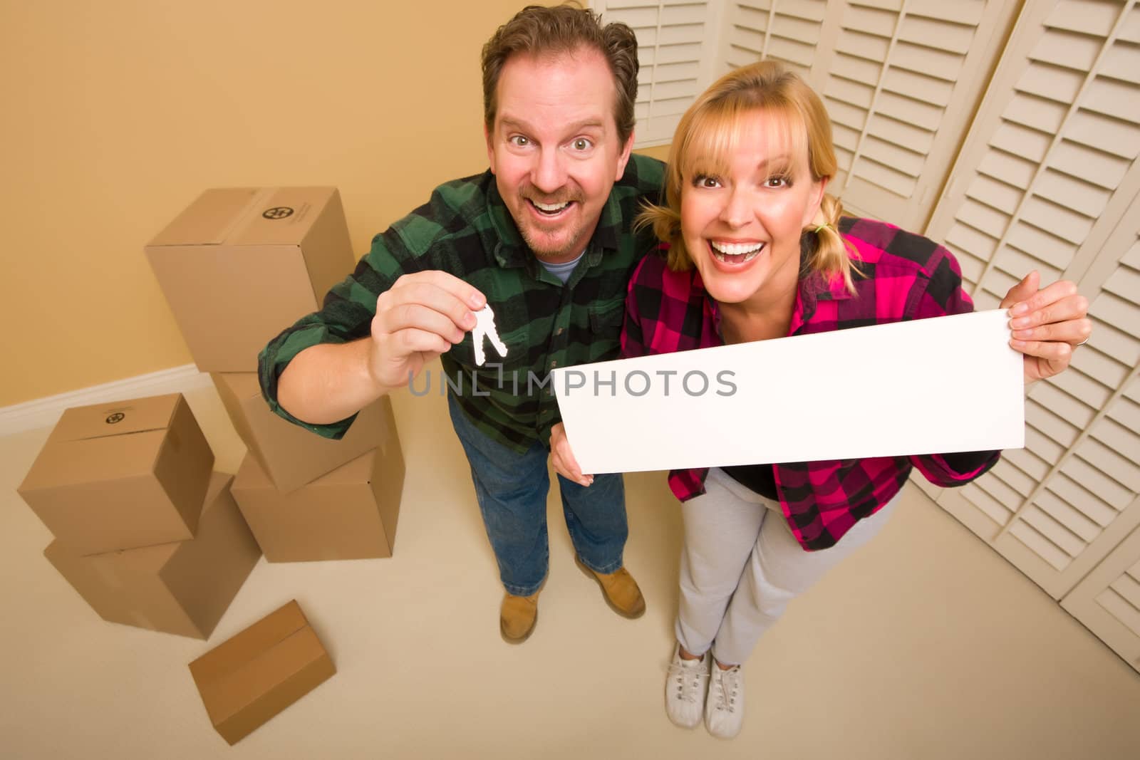 Goofy Couple Holding Keys and Blank Sign Surrounded by Boxes by Feverpitched